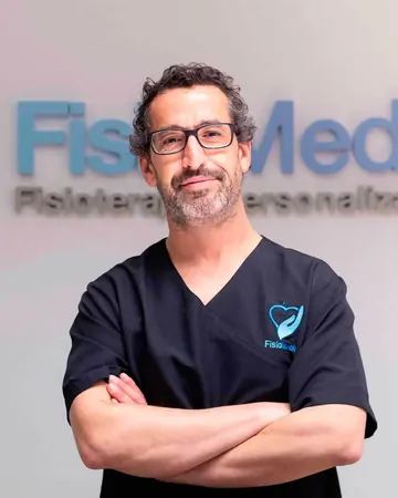 Retrato de Javier Gallego Prados, fisioterapeuta, delante del logo de la clínica