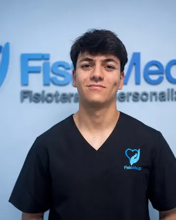 Retrato de Víctor Rubio Langa, fisioterapeuta, delante del logo de la clínica