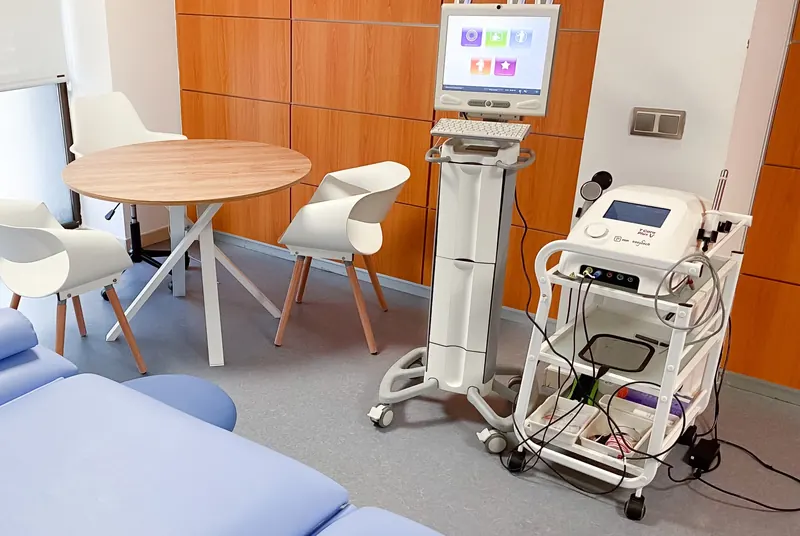Una sala de tratamiento de la clínica, con la camilla y los equipos de electroterapia y ondas de choque